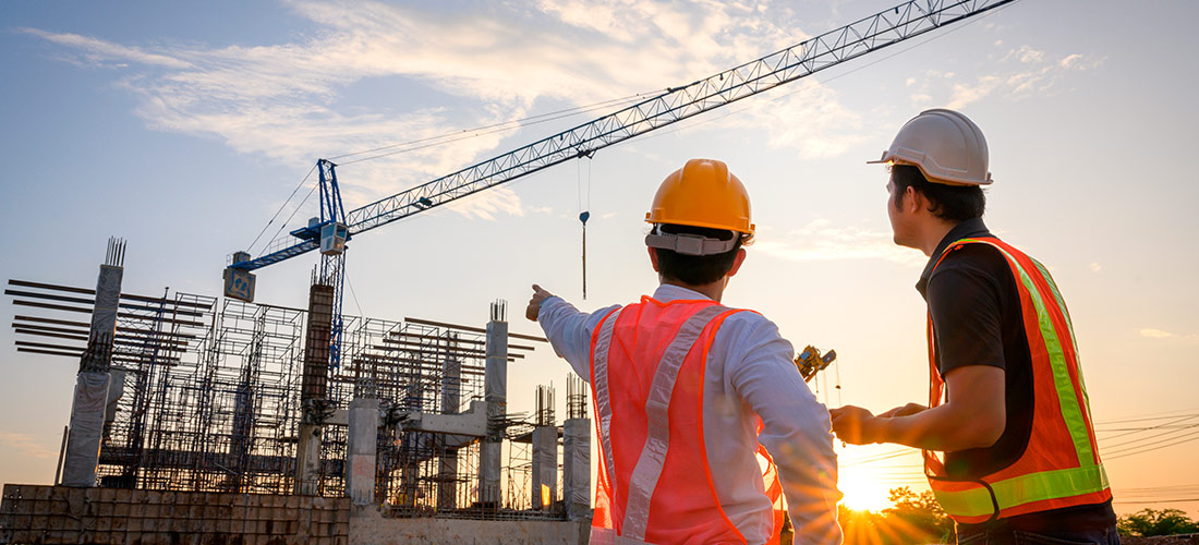 Dos ingenieros comentan el estado de la estructura de la obra de una vivienda.